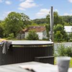Outdoor hot tub with chimney and view of rural surroundings.