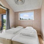 Two beds with white bedding, wooden walls, and window with view of green field.