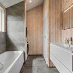 Bathroom with bathtub, washing machine, and mirror cabinet