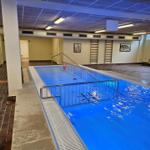 Innenpool mit Metallgeländer und Treppen zur Schwimmfläche.