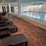 Indoorpool mit Liegestühlen und Terrasse