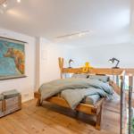 Ein Schlafzimmer mit Holzbett, Karte Europas und Holzfußboden.