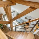 Haus mit Holzständern, Treppe und Essbereich im Erdgeschoss.