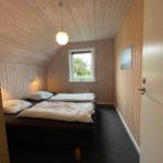 Schlafzimmer mit zwei Betten, Holzwänden und Fenster mit Blick nach draußen.