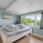 Schlafzimmer mit Bett, Fenster und Holzboden.