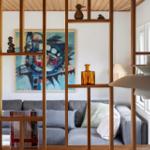 Living area with sofa, wooden shelf, and wall art