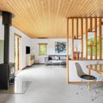 Living space with wooden ceiling, fireplace, sofa, and dining area with table and chairs.