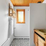 Bathroom with wooden ceiling, sink, and shower.