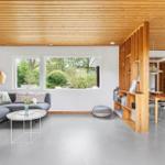 Living room with sofa, table, and bookshelf. Kitchen and terrace are visible.