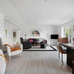 Living and dining area with modern furniture and large windows.