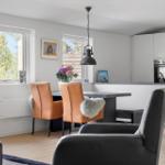 Kitchen and dining area with brown chairs, windows, and modern lighting.