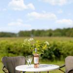 Rundtisch mit Weinflasche und Blumen im Freien