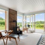 Raum mit Kamin, Sitzgelegenheiten und Blick auf Garten und Feld
