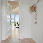 Hallen mit Holzdecke und Blick auf Wasser. Wand mit Korb und Dekoration.