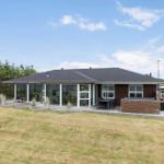 Moderne Villa mit großem Garten und Terrasse mit Sitzgelegenheiten.