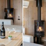 Wohnzimmer mit Kaminofen, Couch und Tisch mit Wein und Gläsern.