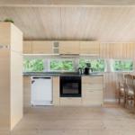 Küche mit Essbereich, Holzelemente und Fenstern zur Natur