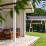 Deck with wooden furniture and swing in the garden