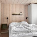 Bedroom with wooden walls, white bed, and wall art