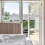 Bedroom with view of terrace and garden. Door and window are open.