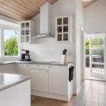 Kitchen with white cabinets, countertop, and view of terrace.