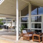 Terrace with seating and view into the house. Backyard with table and chairs.