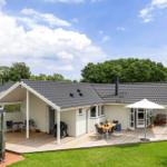 House with terrace, grill, and garden. White facade, dark roof tiles.