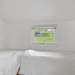 Room with two beds and window view of green area