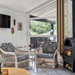 Living room with two chairs, wood stove, and TV mounted on the wall.