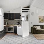 Kitchen with black cabinets and living area with green sofa.