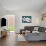 Wohnzimmer mit grauem Sofa, Holzboden und Wandbild