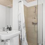 Badezimmer mit Dusche, Waschbecken und Toilette.