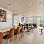 Wohn- und Essbereich mit Holzdecke, Tisch, Stühle und Sofa.