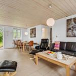 Wohn- und Essbereich mit Ledersofa, Holztisch und Blick auf den Garten.
