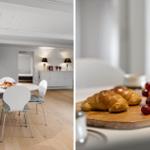 Dining room with white table and chairs. Breakfast board with croissants and grapes.