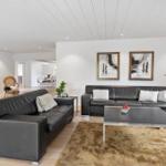 Two black leather sofas, a table, and wall art in the living room.