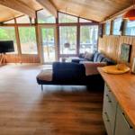 Wohn- und Essbereich mit Holzdecke, Sofa und Küchenzeile.