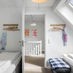 Zwei Schlafzimmer mit Dachschrägen, Kleiderhaken und Fischdekorationen.