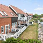 Reihenhäuser mit Terrassen und Blick auf Wasser.