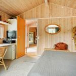 Schlafzimmer mit Holzwand, Bett, Schreibtisch und Blick in den Flur.