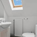 Badezimmer mit Waschbecken, Toilette und Dachfenstern