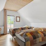 Zimmer mit Doppelbett, Holzdecke und Fenster zur Aussicht.