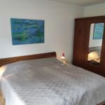 Schlafzimmer mit Bett, Kleiderschrank und Wandbild