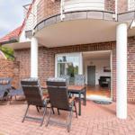 Terrace with seating group and view into the house. Red brick patio with balcony.