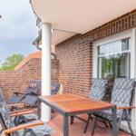 Terrace with table, chairs, and view into kitchen.