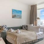 Schlafzimmer mit Bett, Wandbild und Balkonansicht.