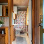 Badezimmer mit Holzwand, Tulpen-Duschvorhang und Waschbecken