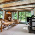 Wohnzimmer mit Holzdecke, Kamin und Blick auf Garten