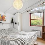 Schlafzimmer mit Bett, Fenster, Schrank und Deckenleuchte.