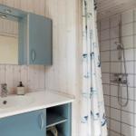 Bad mit Waschbecken, Spiegelschrank und Dusche mit Duschvorhang.